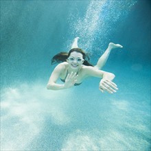 Young attractive woman diving in swimming pool.