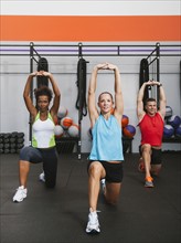 Multiracial group of two women doing aerobic in gym.