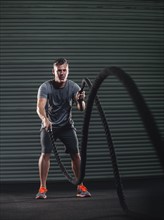 Mature man exercising with rope.