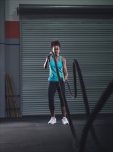 Mid adult woman exercising with rope.