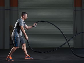 Mature man exercising with rope.