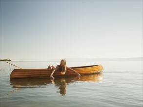 Young woman relaxing in canoe.