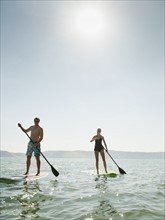 Two people standing on paddleboard.