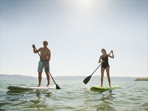 Two people standing on paddleboard. Photo: Erik Isakson