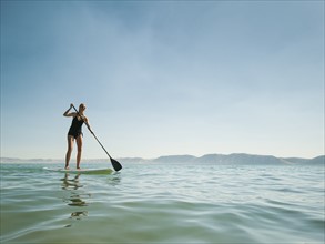 Young woman standing on paddleboard. Photo: Erik Isakson