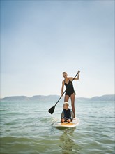 Young woman with daughter (4-5) on paddleboard.
