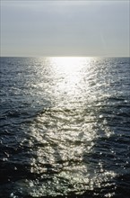 sunlight reflecting on sea. Photo : Tetra Images