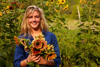 Woman holding bouquet of sunflowers. Photo : John Kelly