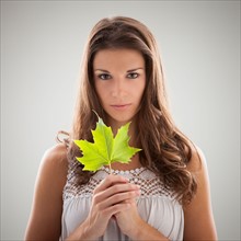 Beautiful woman holding green sycamore leaf. Photo : Mike Kemp