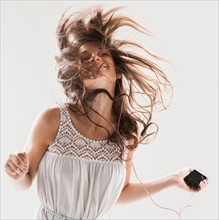 Beautiful woman dancing with portable music player in hand. Photo: Mike Kemp