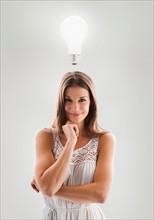 Beautiful woman with lightbulb above her head. Photo : Mike Kemp