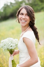 Portrait of happy woman holding flowers and smiling. Photo : Jessica Peterson