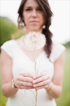 Woman holding dandelion. Photo: Jessica Peterson