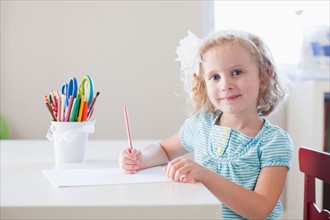 Girl sitting at table and looking at camera. Photo: Jessica Peterson