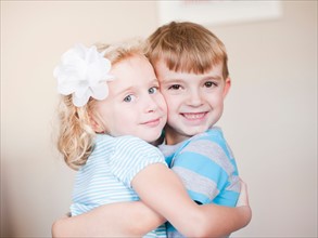 Studio Shot, Portrait of sister and brother hugging each other. Photo: Jessica Peterson