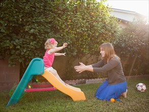 Mother and her daughter playing in backyard. Photo : Jessica Peterson