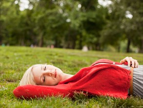 Woman laying on grass with closed eyes. Photo : Jessica Peterson