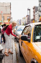 Woman getting yellow taxi. Photo: Jessica Peterson