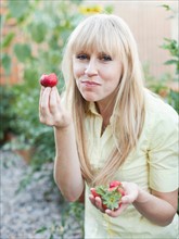 Woman tasting strawberries. Photo: Jessica Peterson
