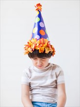 Studio Shot of young boy with hat on his head. Photo : Jessica Peterson