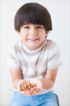 Studio Shot of young boy with almonds. Photo : Jessica Peterson