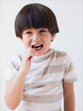 Studio Shot of young boy eating candy. Photo : Jessica Peterson