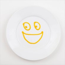 Plate with smiley face made of mustard. Photo : Jessica Peterson