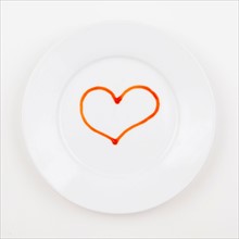 Studio shot of plate with heart made of ketchup. Photo : Jessica Peterson