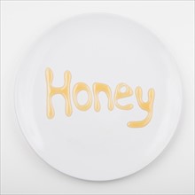 Word HONEY on white plate. Photo: Jessica Peterson