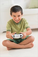 Boy (6-7) playing video game.
