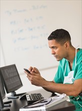 Surgeon working on computer and text messaging.