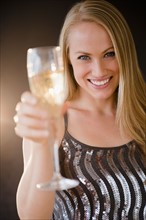Young woman making toast with champagne