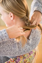 Blonde woman braiding hair