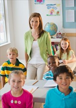 School children (8-9) with female teacher in classroom