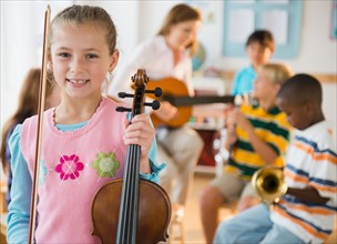 Portrait of schoolgirl (8-9) with violin during music class