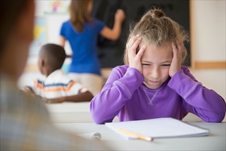 Schoolgirl (8-9) having problems while learning in classroom