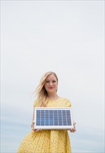 Young woman holding solar panel