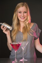 Young woman preparing martini