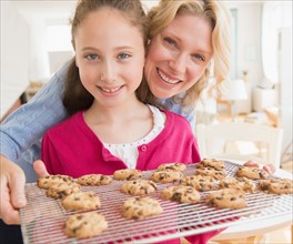 Mother and daughter (8-9 years) baking cookies