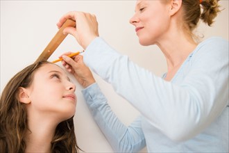 Mother checking girl's (8-9) height