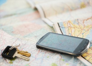 Car keys and smartphone on map