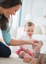Mother with daughter (6-11 months) playing with wooden blocks