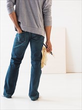 Young man standing against white canvas