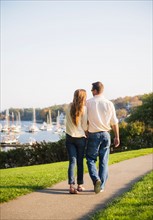 Couple walking with harbor in background