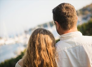 Back view of couple looking at harbor