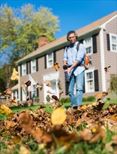 Man using leaf blower in front yard