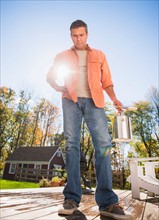 Man standing on porch with paint can