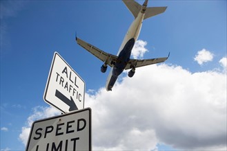 Airplane flying above road signs