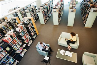 Elevated view of man and woman reading in library