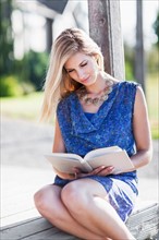 Portrait of woman reading book outdoors